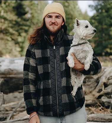 férfi a parton a kezében a kutyájával