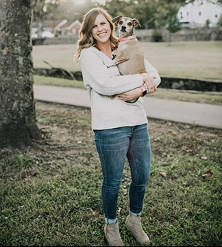 nő a fa alatt kezében a kutyája