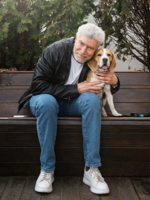 idősebb férfi ül a padon a kutyájával