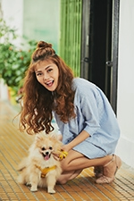 nevető fiatal nő a kis kutyájával